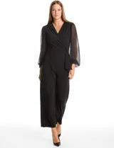 Enterito de seda fría color negro, con escote en V cruzado y cintura elástica con lazo lateral. Presenta mangas largas de gasa transparente con puños elásticos fruncidos y pantalón de corte recto al tobillo.