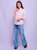 Camisa de mujer entallada con diseño de rayas verticales en tonos celeste y azul, manga larga con puños abotonados y cuello clásico.