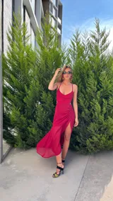 Vestido midi de crepé color magenta, con escote corazón, tirantes finos y falda con frunces laterales y tajo pronunciado.