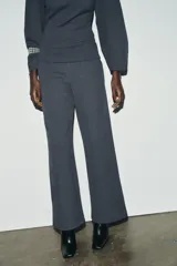 Pantalón de tiro alto con corte ancho y recto, confeccionado en tejido de punto elástico y flexible con cintura elástica.