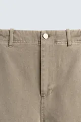 Pantalón cargo de corte relajado con efecto lavado, confeccionado en tejido de algodón. Presenta bolsillos frontales, bolsillos traseros con solapa y bolsillos con cierre de cremallera en las perneras. Incluye pliegues en las rodillas y ajuste en los tobillos.