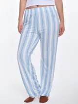 Pantalón de dormir de corte recto y calce relajado, confeccionado en viscosa con tacto suave. Presenta un diseño a rayas verticales en tonos blanco y azul, con sutiles detalles en rojo. Cuenta con cintura elastizada para mayor comodidad.
