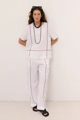Pantalon de lino color beige, de corte recto y holgado, con costuras decorativas pespunteadas en tono contrastante.