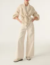 Cárdigan color crema de tejido calado con mangas abullonadas y cinturón para atar.