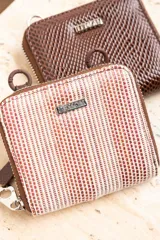 Cartera pequeña color terracota con textura tejida, cierre con cremallera y cadena gruesa marrón para colgar al hombro.