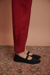 Pantalón de vestir color bordó, de corte recto, con pinzas en la cintura, pretina ancha y bolsillos laterales y traseros. Se ajusta a la cintura con cinturón trenzado dorado.