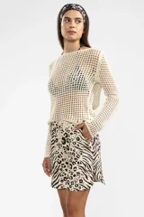 Sweater de tejido calado color crema, de manga larga y con cuello bote.