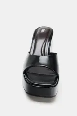 Sandalias de tacón tipo cuña alta con diseño estilo mule, color negro, con tira delantera ancha y puntera cuadrada.