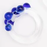 Anillo artesanal de vidrio transparente con diseño irregular y esferas decorativas en color azul cerúleo.