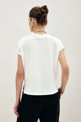 Remera blanca de algodón con cuello en V, mangas cortas y calce relajado.