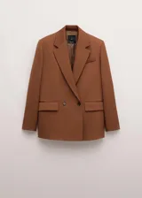 Blazer de corte sastrero color tostado, con diseño de doble botonadura, solapas clásicas y bolsillos laterales con solapa.