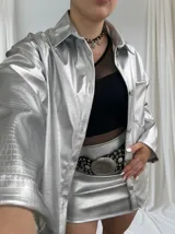 Sobrecamisa plateada con textura croco, cuello camisero, manga larga y cierre frontal con botones.