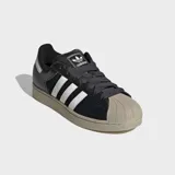 Championes Adidas Superstar II, color negro con las tres bandas características en blanco y suela de goma en tono tostado con la clásica puntera de goma.
