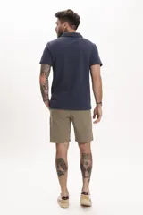 Remera tipo polo azul marino de manga corta con cuello clásico y cierre de dos botones. Presenta un pequeño bordado de un pájaro en el pecho.