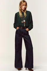 Camisa verde oscuro con cuello de volante y manga larga, detalles de entredoses a tono y cierre frontal con botones forrados.