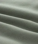 Bermuda de corte sastrero color verde oliva, confeccionada en mezcla de viscosa y lino. Presenta pliegues frontales, bolsillos laterales, trabillas para cinturón y cierre frontal con botón y cremallera.