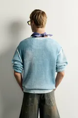 Jersey de punto de corte relaxed fit confeccionado en hilatura de algodón, con cuello redondo y manga larga. Presenta un diseño de efecto lavado con costuras en contraste y acabados en rib.