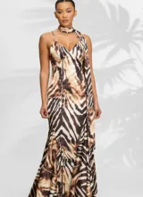 Vestido largo de fiesta con estampado animal print, confeccionado en tela fluida. Presenta un diseño con breteles finos, escote en V y un detalle de pañuelo integrado al cuello que cae sobre uno de los hombros.