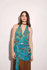 Vestido largo amarillo con escote halter y detalle de volados en el cuello. Presenta un diseño superpuesto con una capa superior estampada a cuadros multicolor con nudo lateral en la cintura y una falda fluida lisa con abertura lateral.