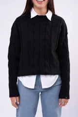 Sweater de punto con diseño de ochos, color marrón, cuello redondo y mangas largas con puños acanalados.
