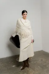 Chal de punto color crudo con textura suave y terminaciones con flecos largos en todo el borde.