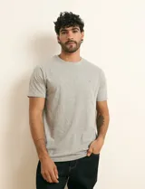 Remera básica de algodón color beige, de manga corta, con cuello redondo y un pequeño detalle bordado en el pecho.