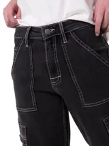 Pantalón cargo de jean gris oscuro con tiro alto, corte relajado, bolsillos laterales con solapa y costuras pespunteadas en contraste.