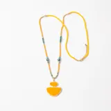 Collar largo con dije geométrico doble en color amarillo, compuesto por una cadena de cuentas amarillas pequeñas, cuentas metálicas y detalles en verde, con cierre de mosquetón y cadena de alargue.