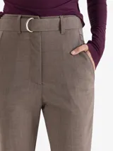 Pantalón de vestir color gris, de corte regular y largo tobillero. Presenta cintura alta con trabillas, cierre frontal con doble gancho y un cinturón desmontable con hebilla metálica.