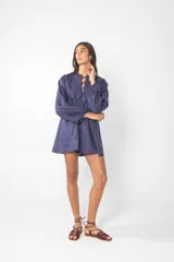 Vestido corto azul con escote con cordones, mangas largas abullonadas y corte evasé.