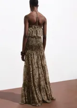 Vestido largo de cuello halter con estampado de leopardo. Presenta un diseño con cuerpo fruncido y un volante en la parte superior, confeccionado en tejido fluido con caída.