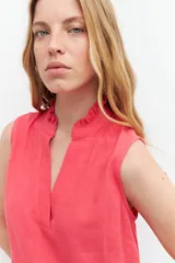 Vestido corto fucsia de lino, sin mangas, con cuello mao con volados y volado en el ruedo.