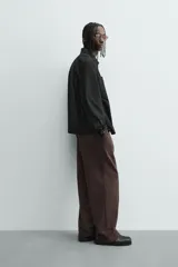 Cazadora azul marino de corte regular fit, confeccionada en tejido técnico repelente al agua. Presenta cuello subido, manga larga, bolsillos de vivo en cadera, bolsillo interior y acabados en rib en puños y bajo. Cierre frontal de cremallera oculta por solapa con botones a presión.