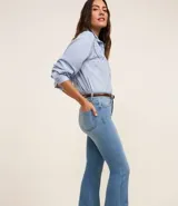 Pantalón flare de jeans con elastano, tiro alto, bolsillos delanteros y traseros, cierre con botón y cremallera, trabillas en la cintura.