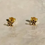 Par de aros dorados con forma de estrella de cinco puntas, con incrustaciones de circonitas negras.