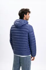 Campera capitoneada de color azul con capucha, cierre frontal y diseño acolchado.