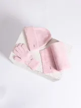 Set de accesorios de invierno en color rosado jaspeado, compuesto por un gorro tipo beanie, un par de guantes y una bufanda de tejido de punto acanalado. Cada pieza incluye una pequeña placa metálica decorativa.