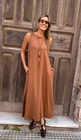 Vestido largo color caramelo, de corte recto y holgado, con cuello redondo y bolsillos laterales.
