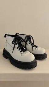 Botas de caña baja color blanco con suela chunky y cordones negros.