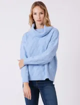 Buzo de punto grueso con textura en relieve, de cuello volcado y mangas largas con hombros caídos. Presenta puños y ruedo con terminación en rib.