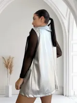 Chaleco largo plateado con textura simil piel de reptil, solapas y bolsillos delanteros.