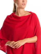 Poncho tejido de punto con diseño asimétrico y aberturas laterales para los brazos.