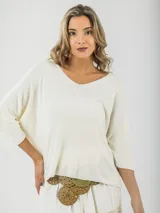 Sweater tejido fino italiano color crudo, con escote en V y mangas 3/4. Diseño holgado y liviano.