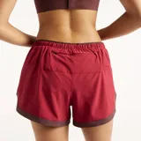 Short de running New Balance modelo RC Essential, color bordó con cintura elástica y detalles en contraste, equipado con tecnología NB DRY de secado rápido y bolsillos.