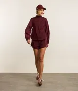 Campera deportiva femenina, modelo rompevientos, confeccionada en poliamida, con cuello alto y puños ajustados. Sin estampa, tiene cierre delantero con cremallera y recortes con hilo reflectante.