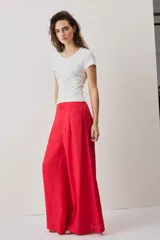 Pantalón rojo de corte ancho, estilo palazzo, tiro alto y bolsillos laterales.