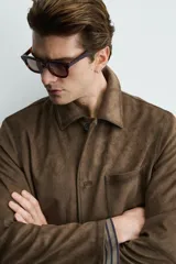 Sobrecamisa de corte regular fit confeccionada en tejido con efecto ante. Presenta cuello solapa, cierre frontal con botones, mangas largas y tres bolsillos frontales de plastrón. Incluye costuras con acabado efecto envejecido.