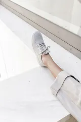 Zapatilla de diseño minimalista confeccionada en lana merino, con cordones al tono y suela de EVA. Presenta un estilo atemporal y versátil, ideal para uso diario.