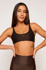 Top deportivo negro reversible con diseño slim, tirantes finos y espalda descubierta. Un lado tiene acabado brillante y el otro textura 3D tipo colmena.