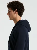 Buzo azul marino con capucha, cierre completo y bolsillos frontales. Confeccionado en tejido de felpa suave y cálido, con logo de pingüino bordado en el pecho.